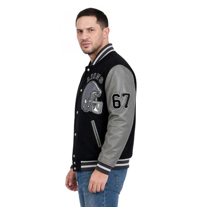 Man wearing a black and gray varsity jacket with letterman design on a white background