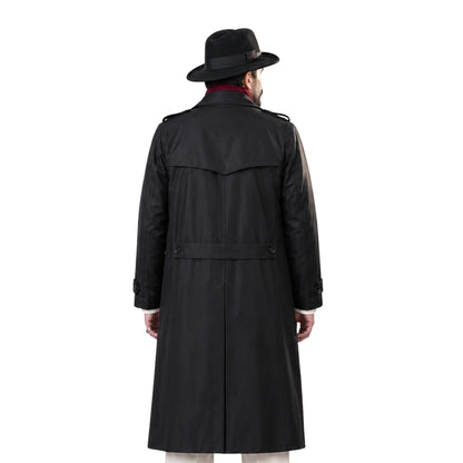 Man wearing a black trench coat and hat on a white background