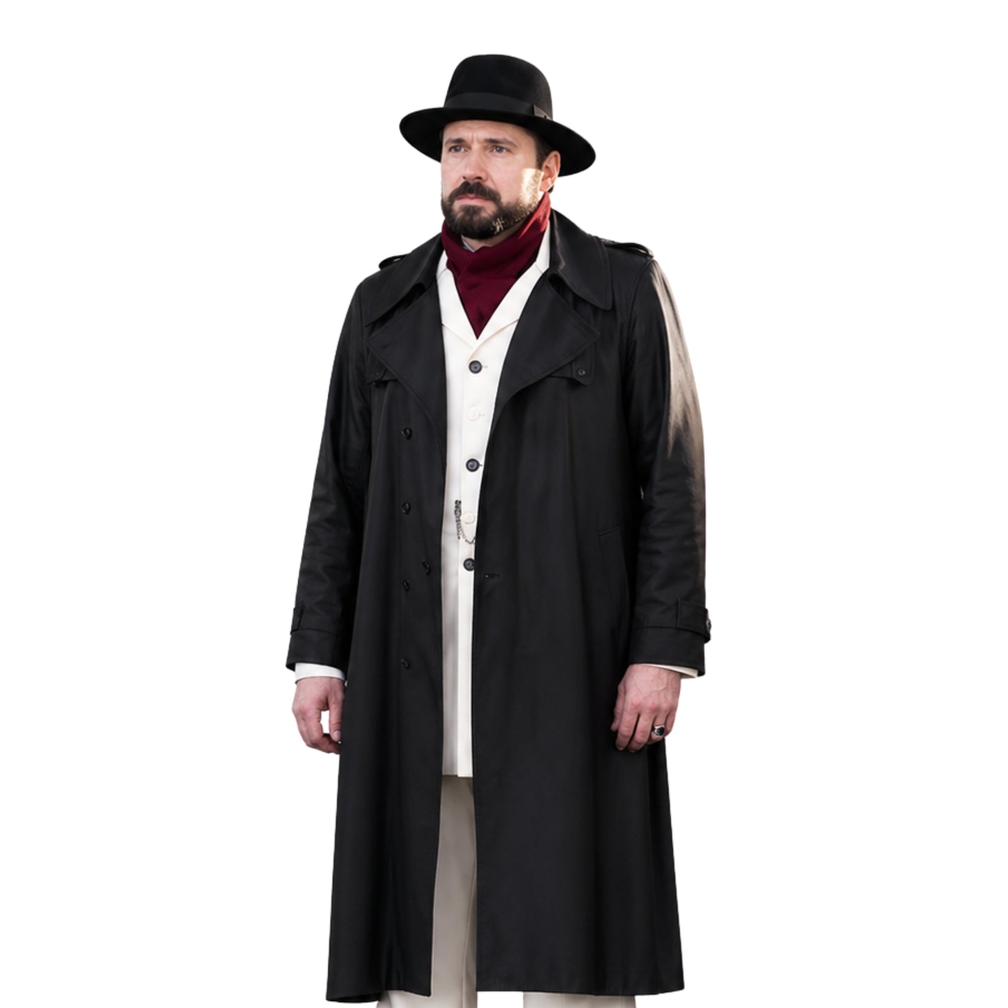 Man wearing a long black coat, hat, and red sweater on a white background