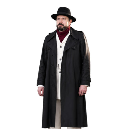 Man wearing a long black coat, hat, and red sweater on a white background