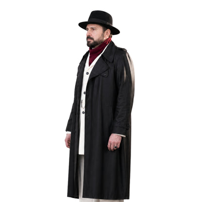 Man wearing a long black coat, white shirt, and black hat on a white background