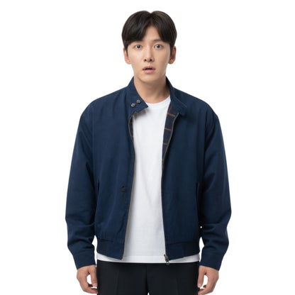 Man wearing a navy blue jacket over a white shirt on a white background