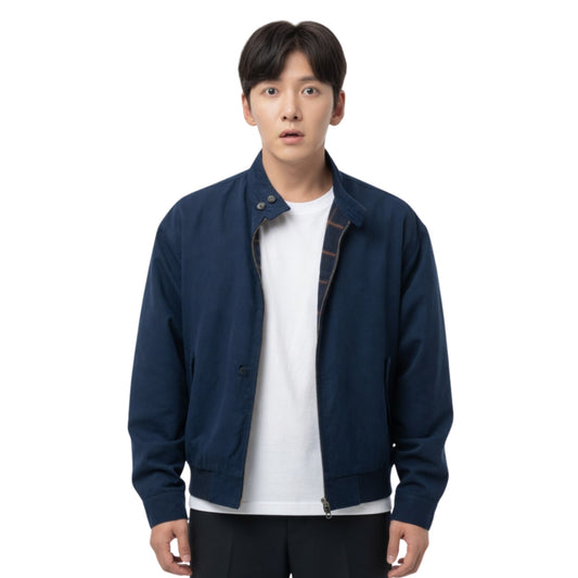 Man wearing a navy blue jacket over a white shirt on a white background