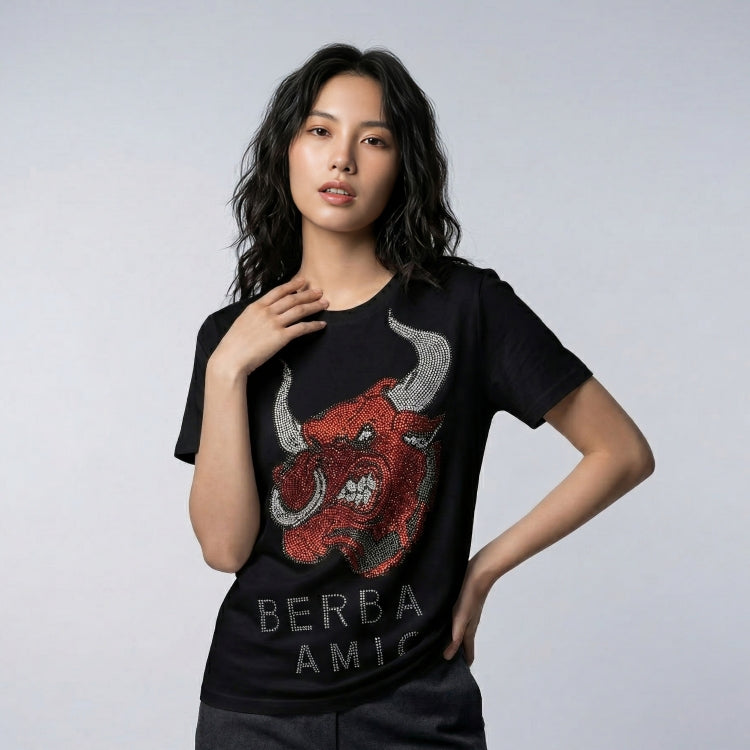 Woman wearing a black t-shirt with a red bull graphic and 'BERBA AMIC' text on a gray background