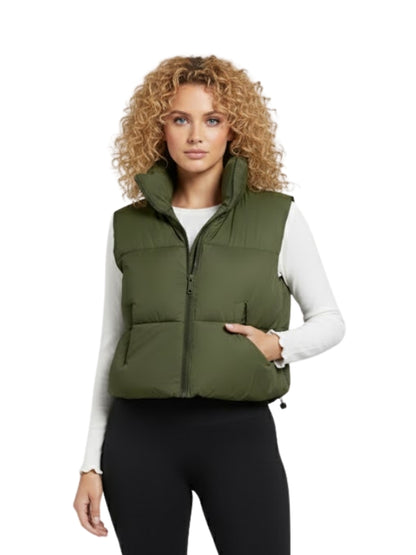 Woman wearing a green puffer vest on a white background