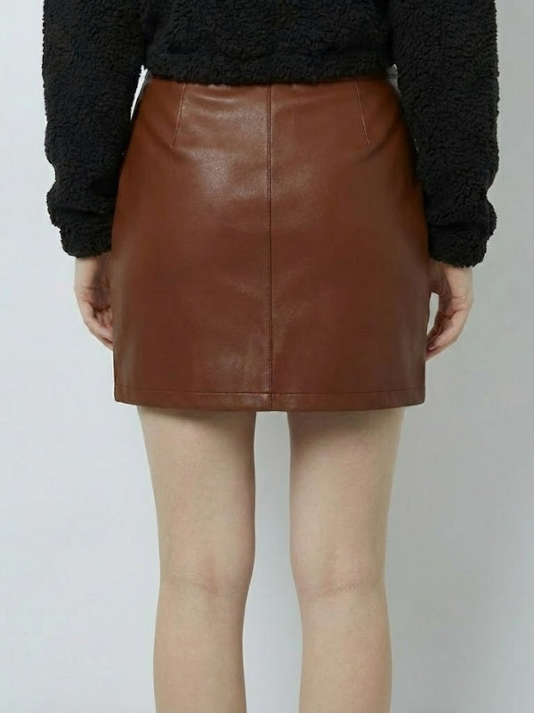 Brown leather skirt worn by a person on a plain background