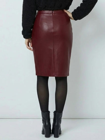 Person wearing a burgundy leather skirt with black tights and boots on a white background