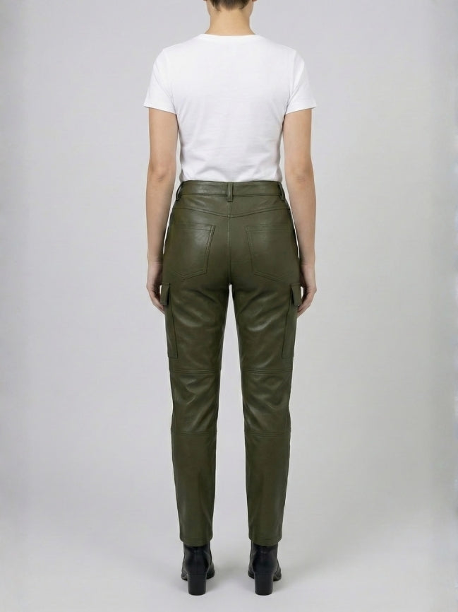 Person wearing green leather pants on a plain background