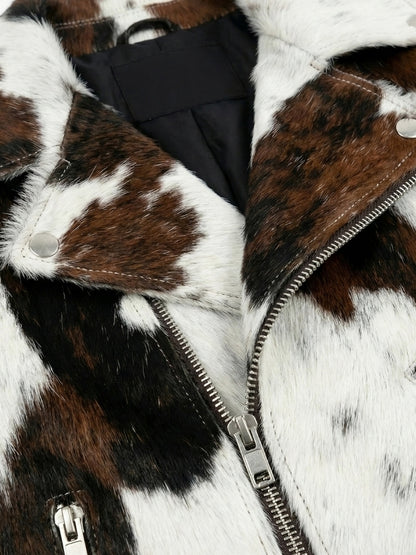 Close-up of a fur coat with a zipper, featuring brown, white, and black patches.