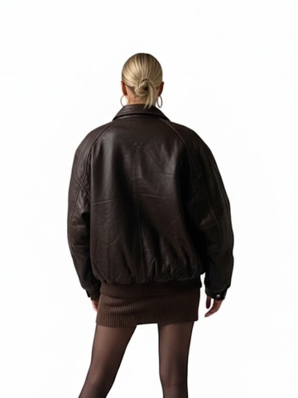 Person wearing a brown leather jacket and skirt on a white background