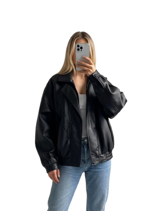 Person wearing a black leather jacket and blue jeans on a white background