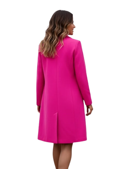 Woman wearing a bright pink coat on a white background