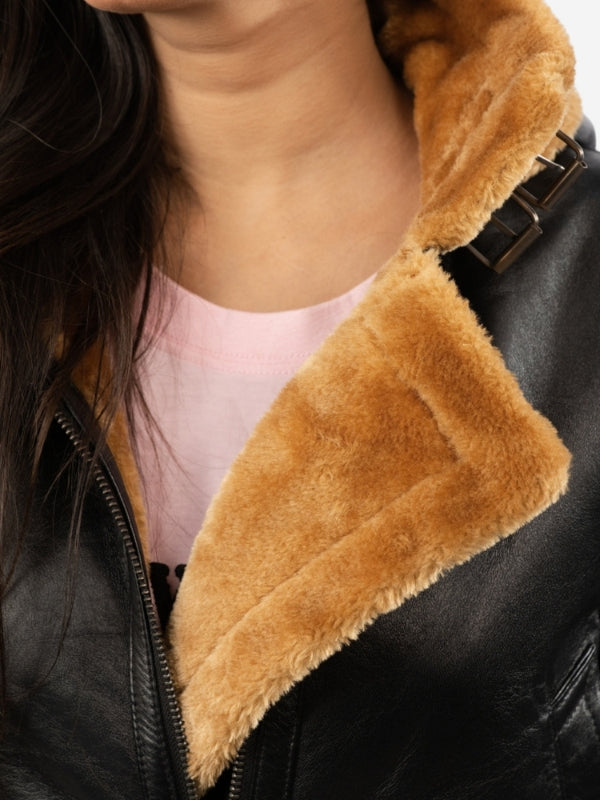 Close-up of a person wearing a black leather jacket with a brown fur collar.