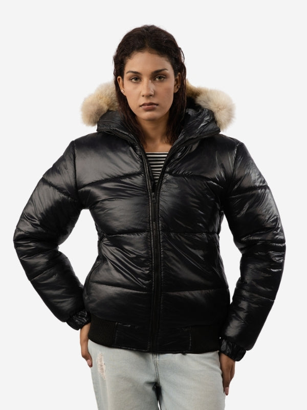 Woman wearing a black puffer jacket with fur hood on a white background