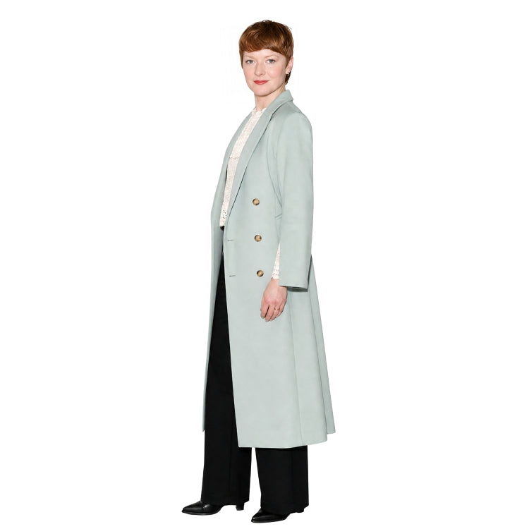 Woman wearing a light blue coat with gold buttons on a white background