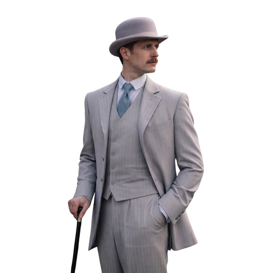 Man in a gray suit and hat holding a cane on a white background