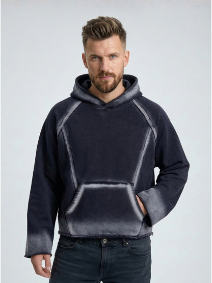 Man wearing a dark gray hoodie with a light gray gradient on a light gray background